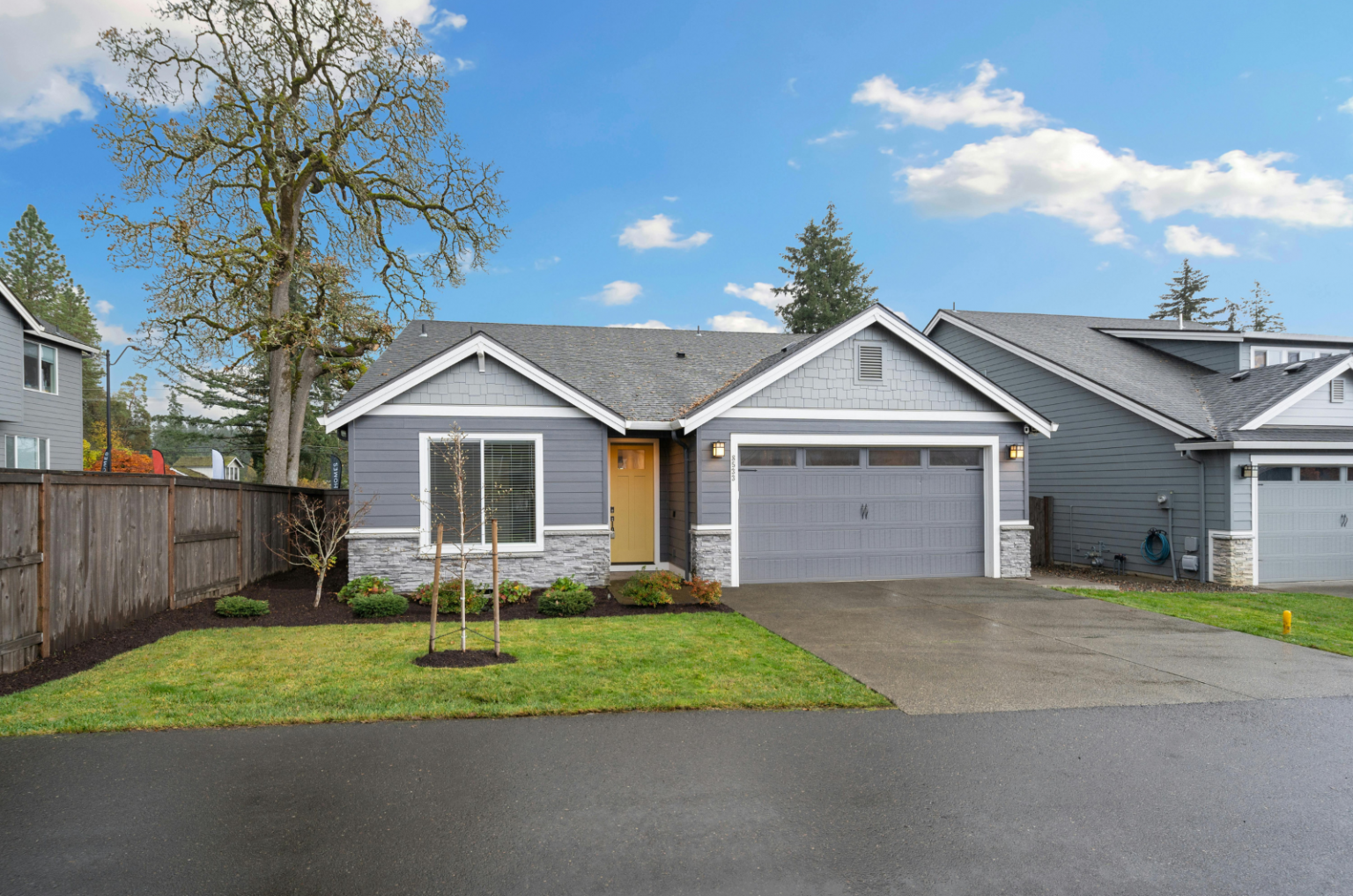 Modern gray suburban home with attached garage and neat front lawn