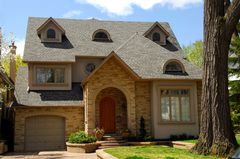 Modern stone house with steep roof and front garden