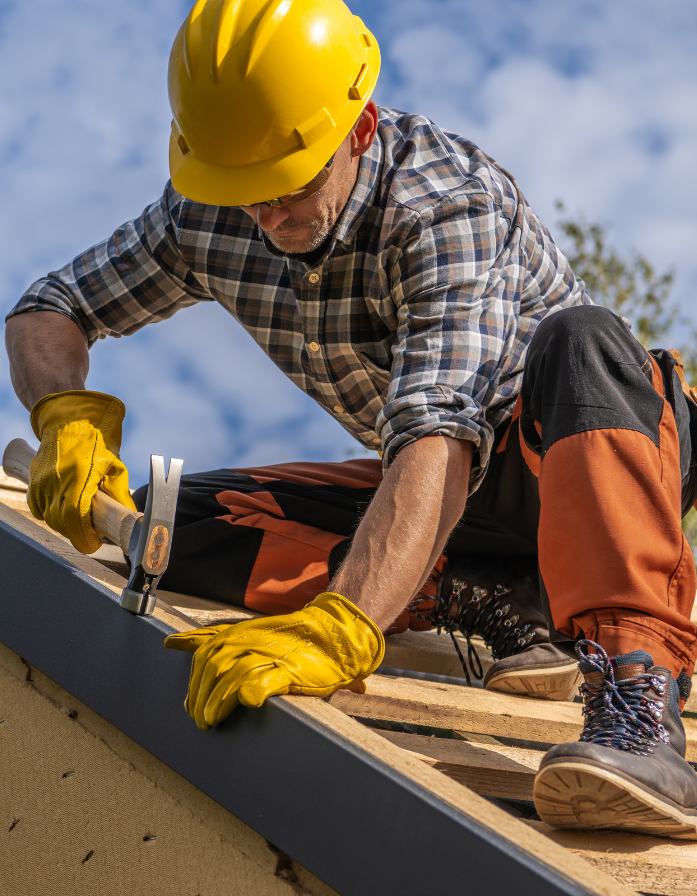Roofer installing metal flashing on residential roof
