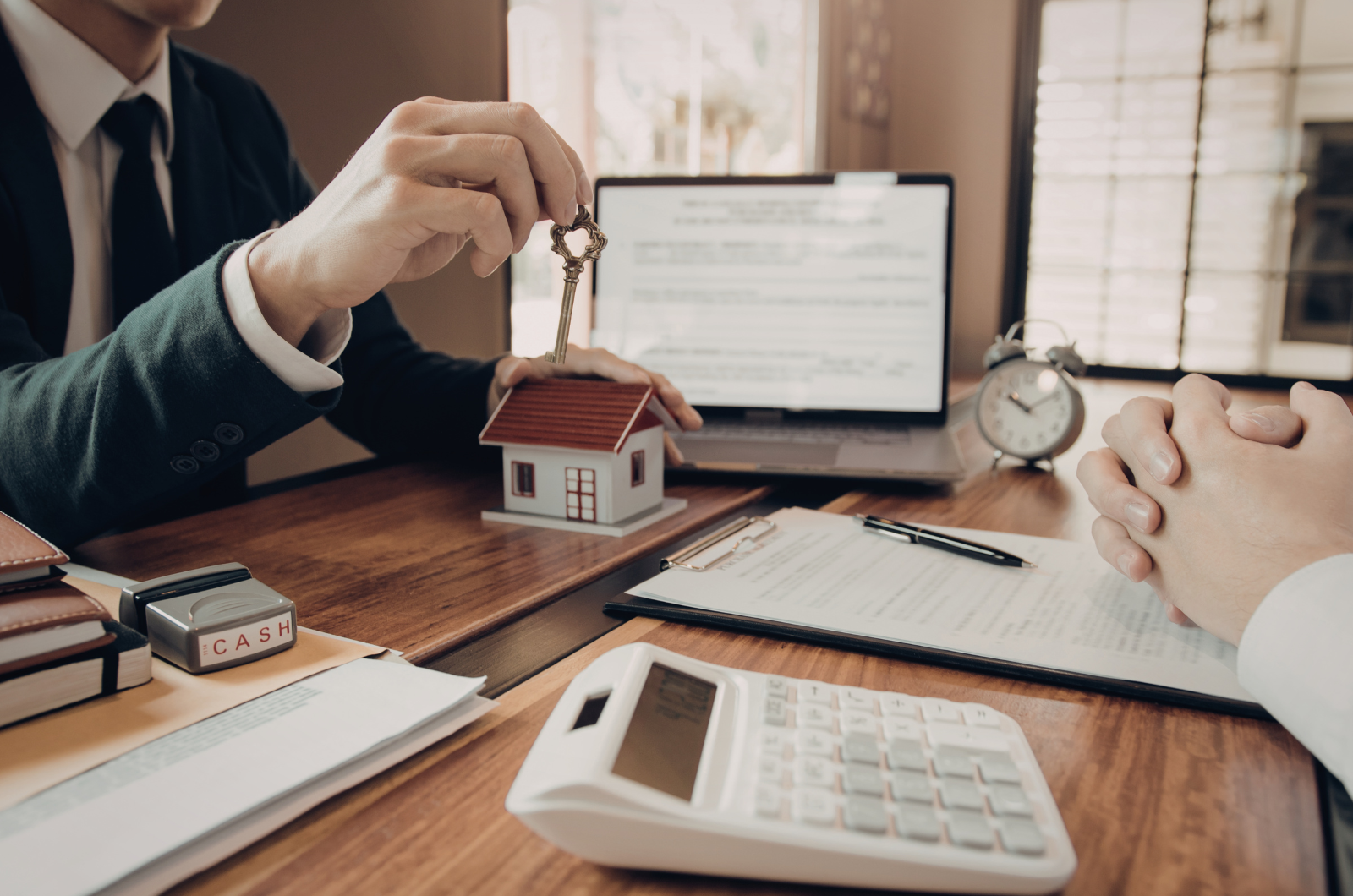 Agent handing over house key during mortgage agreement